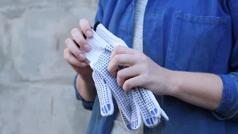 Close-up of female hands holding construction gloves Stock Footage 317077947