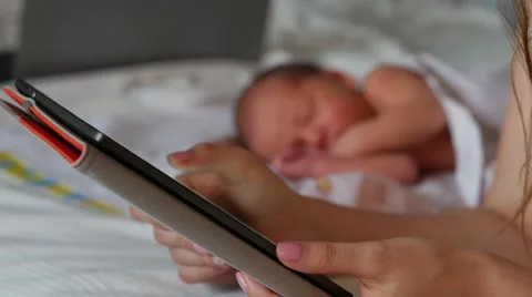Close up of female hands holding e-reader. Dreaming newborn on the background 스톡 동영상 67209272