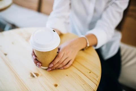 Close up of female hands holding recyclable coffee cup. Stock Photos