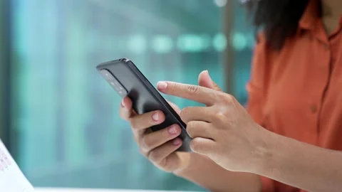 Close up of female hands holding using mobile phone in business office. African  Stock Footage 308238129