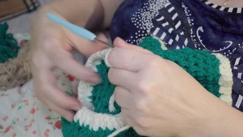 Close up of female hands knitting white and green woolen thread Stockbeeldmateriaal 125020441