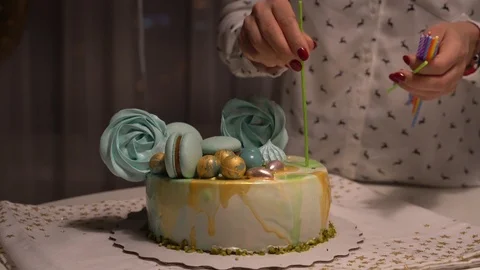 Close up of female hands lighting candles on tasty birthday cake. Prepearing for Stockbeeldmateriaal 101464366