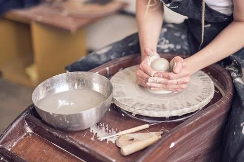 Close up female hands make dishes from clay. woman hands working on potters Foto stock