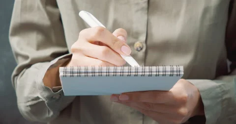 Close up of female hands making notes or drawing with pen in notebook Stock Footage 131073381