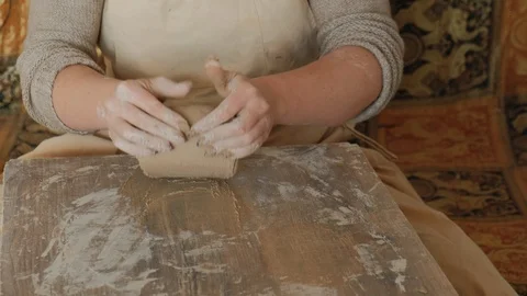 Close-up female hands mixing clay ball before working on a pottery wheel Видео 101702908