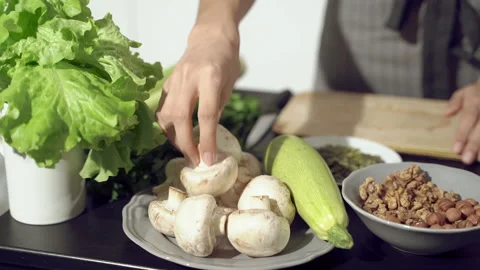 Close up of female hands picking champignons for cooking in the kitchen Video stock 133342690