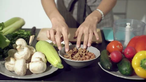 Close up of female hands picking nuts for making salad or sauce. Stock Footage 133336179