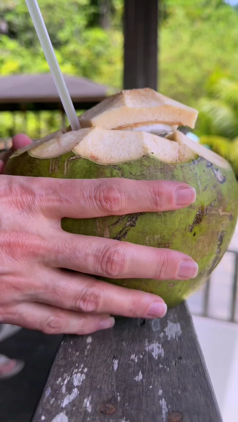 Close up of female hands piercing fresh green coconut with straw, tactile Stock Footage 337104345