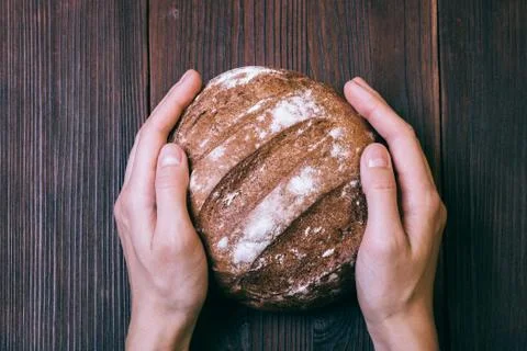 Close-up of female hands placed on the table of fresh bread Stock Photos