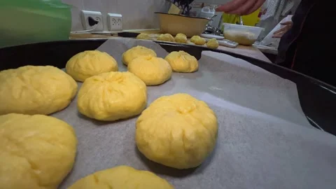 Close-up of female hands placing raw manty dumplings on oven tray Stock Footage 330164098