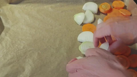 Close up of female hands placing sliced onion and carrot onto parchment paper Stock Footage 346316836