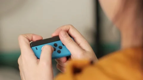 Close up of female hands playing digital video games and the Nintendo Switch gam Stock Footage 194991917
