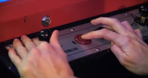 Close up of female hands playing a red and black button vintage arcade game and Stock Footage 91999142