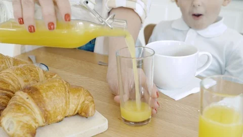 Close-up of female hands pouring orange juice into a glass. Breakfast. Stock Footage 117106970