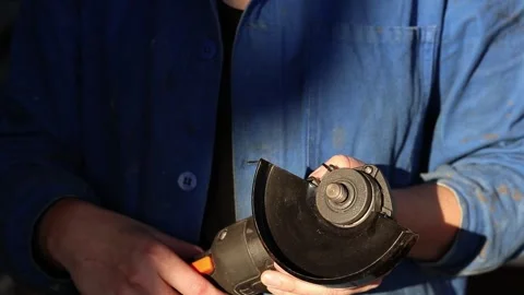 Close-up of female hands preparing cordless angle grinder for work Stock Footage 317686200