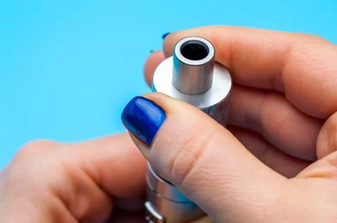 Close-up - female hands preparing device to vaping e-cigarette. Stock Photos