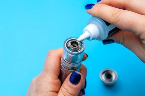 Close-up - female hands preparing device to vaping e-cigarette. Stock Photos