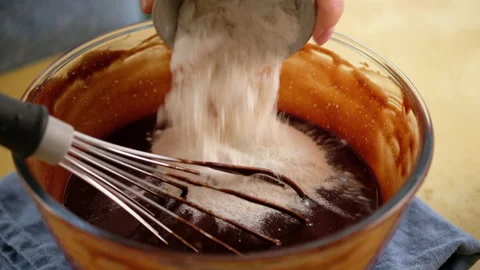 Close-up of female hands preparing the dough for a chocolate cake. Cooking Stock Footage 145087897