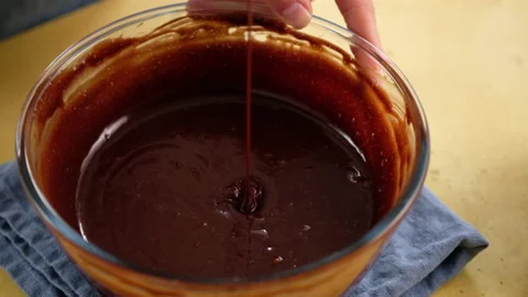 Close-up of female hands preparing the dough for a chocolate cake. Cooking Stock Footage 145088205