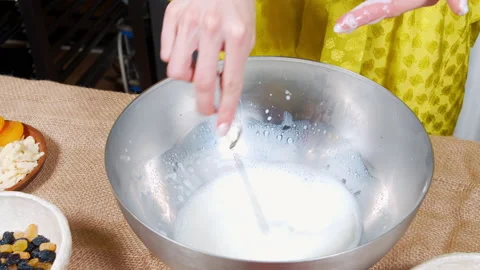 Close-up of female hands preparing dough for tasty cakes with raisins and dried Stock Footage 153357416