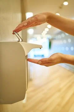 Close-up female hands press the diffuser for liquid alcohol hand sanitizer and Stock Photos