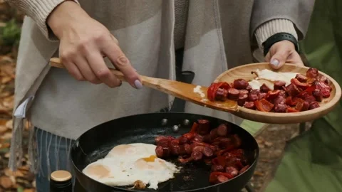 Close up of female hands put hot food from frying pan on a wooden plate Stock Footage 280026408