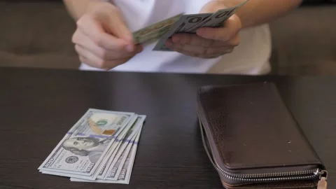 Close up of female hands puts on the table and count american cash money. Female Stock Footage 208853016