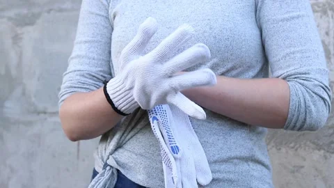Close-up of female hands putting on construction gloves. Woman holding rebar Stock Footage 317078256