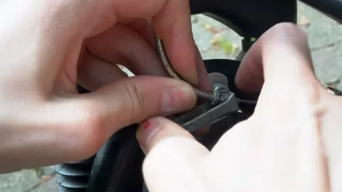 Close up female hands release a brake cable on a bike with front shock absor Stock Footage 276423755