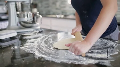 Close-up of female hands rolling dough with pin on wooden table Stock Footage 78927134