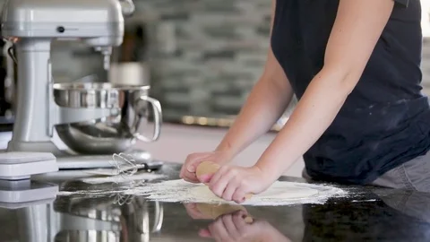 Close-up of female hands rolling dough with pin on wooden table. Stock Footage 78927377