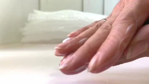Close-up of female hands rubbing thick white cream into dry, fading skin Stock Footage 264351489