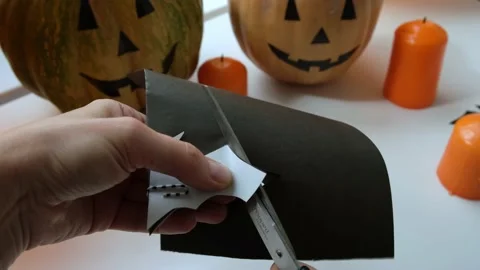 Close up of female hands with scissors cut paper black bat on the background Stock Footage 162088703