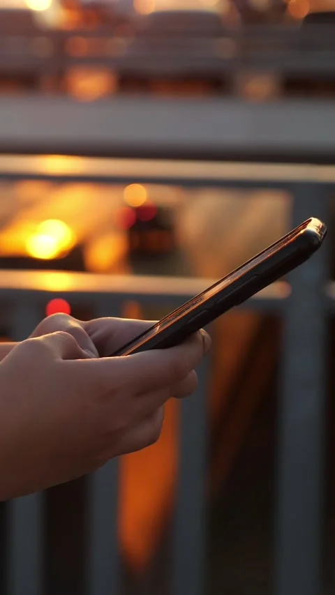 Close up of female hands scrolling and swiping on a smartphone screen outdoors Stock Footage 341446200