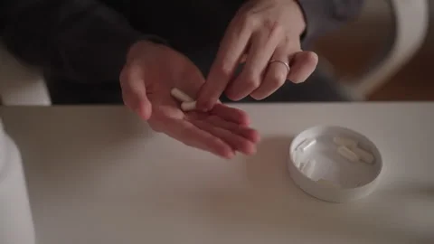 Close-up of female hands selecting and holding capsule medication while managing Stock Footage 320287947
