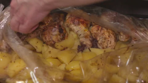 Close-up of Female Hands Serving Baked Chicken and Potatoes from Roasting Bag Stock Footage 335229842