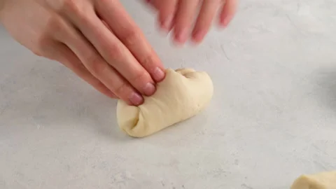Close-up of female hands shape a round bun for hamburgers from dough on a table Stock Footage 145093992
