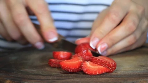 Close up of female hands slice fresh large strawberries for later use Stock Footage 109408669