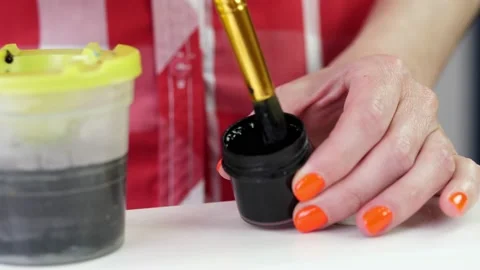 Close-up, female hands slowly interfere with black paint in jar, protests Stock Footage 132326163