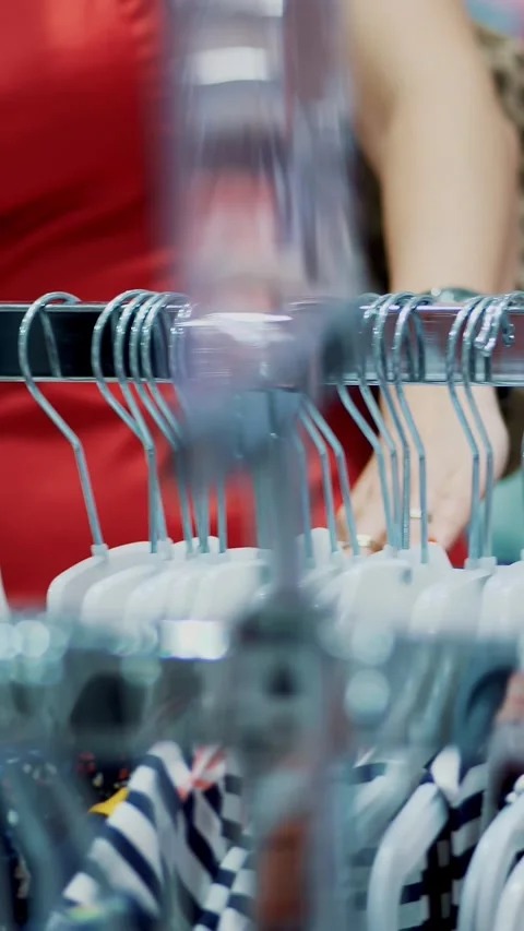 Close-up, female hands sorted out many hangers with outfits. selection and Stock Footage 318075711