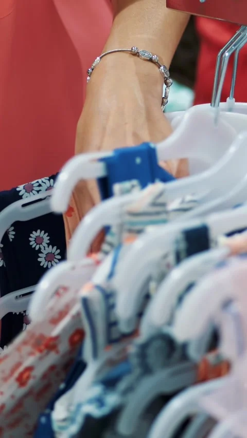 Close-up, female hands sorted out many hangers with outfits. selection and Stock Footage 318590503
