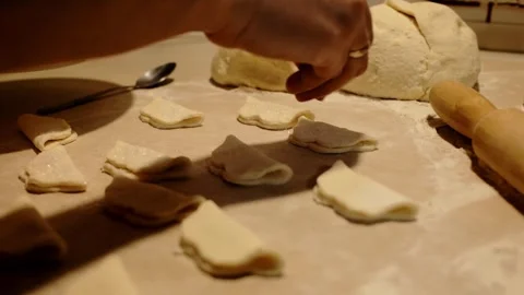 Close-up of female hands sprinkling sugar over pieces of dough while preparing Stock Footage 316611366