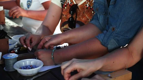 Close-up of female hands stringing beads on a thread, making a jewelry bracelet Stock Footage 119646969
