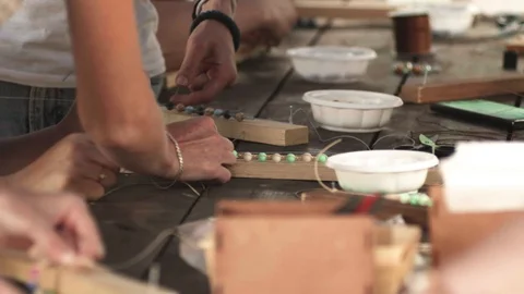 Close-up of female hands stringing beads on a thread, making a jewelry bracelet Stock Footage 119648627