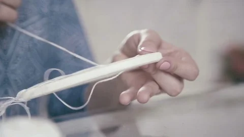 Close-up of female hands tied with thread and weave round basis Video stock 72962962