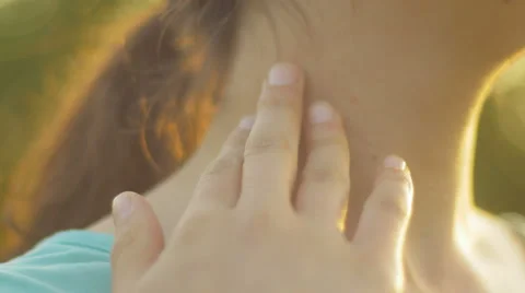 Close-up of female hands touching a neck in the sunlight Stock Footage 66772457