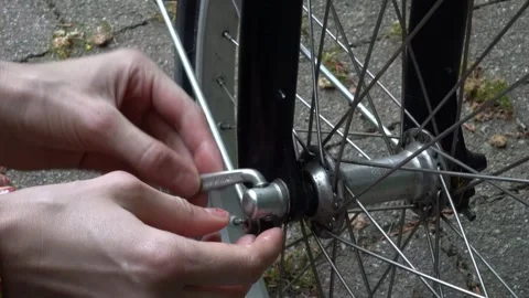Close up female hands try to open a quick release on a bike wheel Stock Footage 276423764