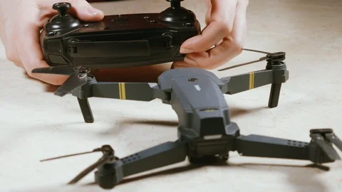 Close - up of female hands trying to turn on the quadcopter Stock Footage 105301606