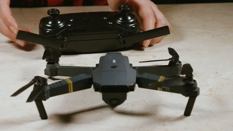 Close - up of female hands trying to turn on the quadcopter Stock Footage 105301696