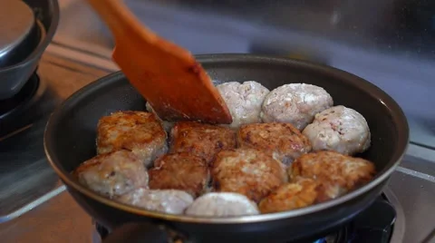 Close up of Female Hands Turning Meat Cutlets in a Frying Pan Stockbeeldmateriaal 47008394